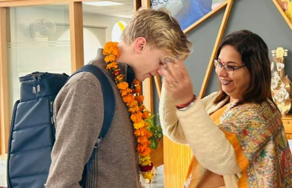 Eleven Felix får en blomsterkrans runt halsen på Kunskapsskolan i Indien.